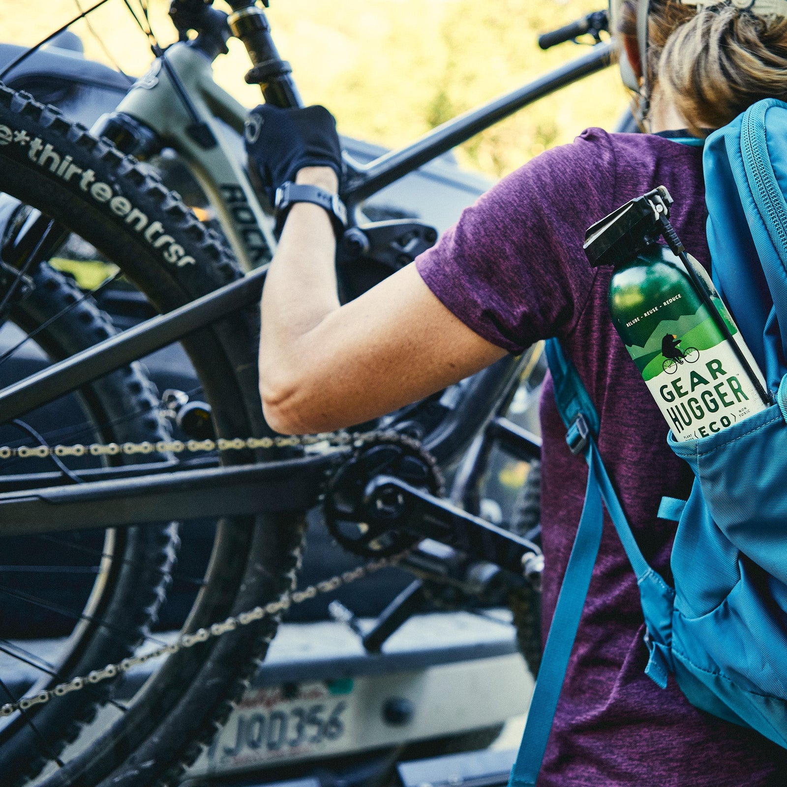 Woman applying Gear Hugger eco-friendly lubricant to bicycle chain for maintenance