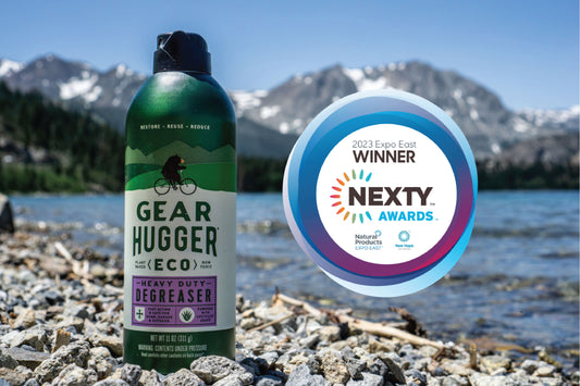 award badge next to a bottle of gear hugger non toxic spray lubricant on a beach