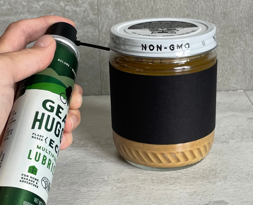 Using Gear Hugger eco-friendly lubricant to loosen a stuck jar lid in kitchen