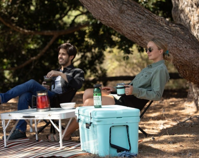 Two people enjoying outdoor camping with eco-friendly gear maintained using plant-based lubricant