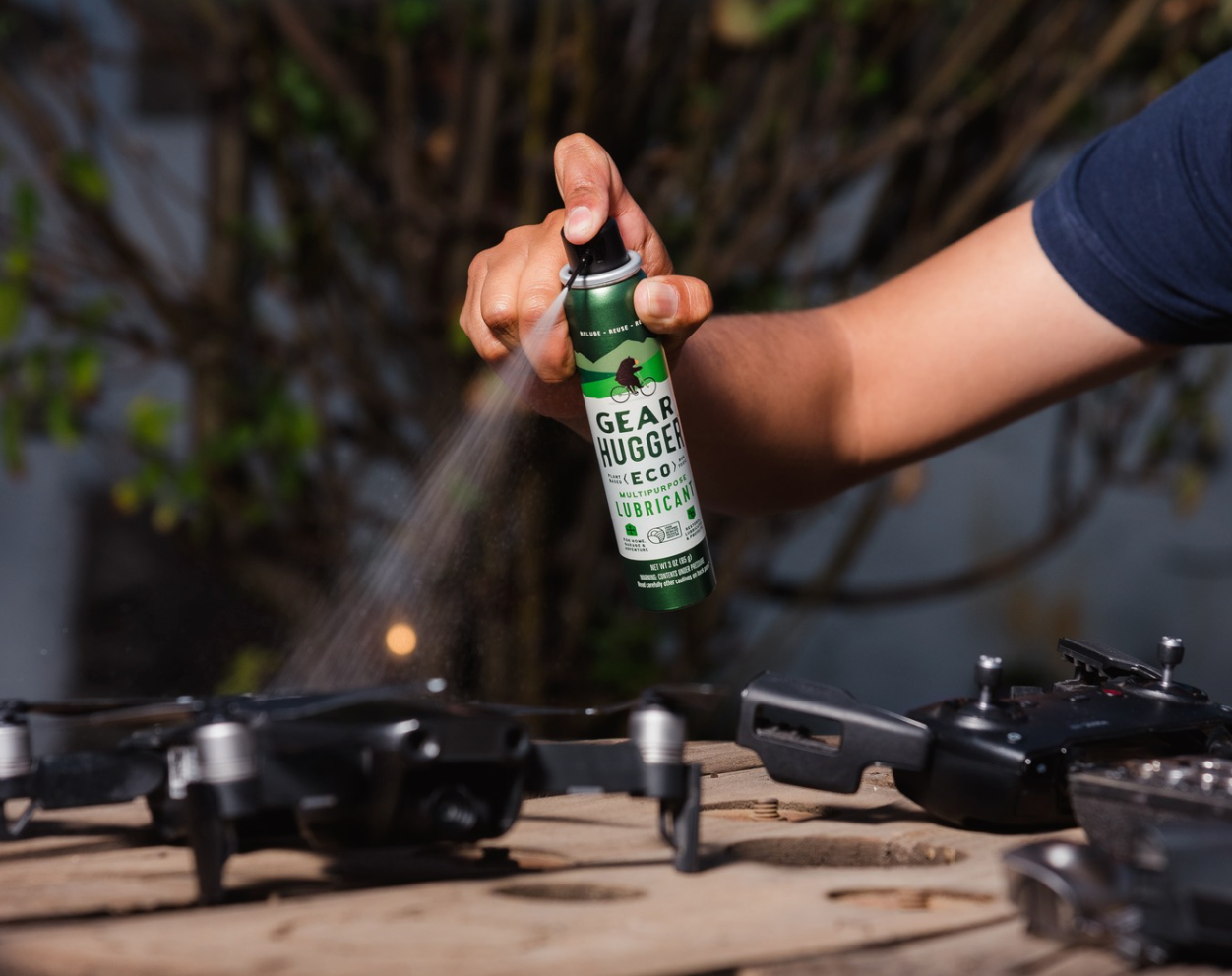 Person applying eco-friendly plant-based lubricant spray to drone blades and exterior electronics