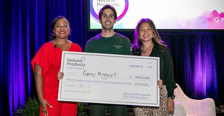 Gear Hugger founder Checo Diaz holding winning prize check at Expo East Pitch Slam