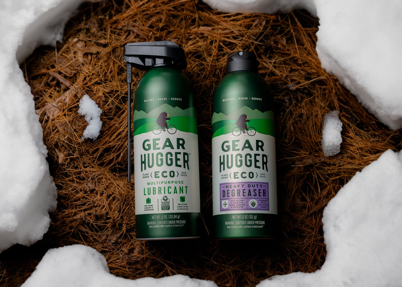 Two Gear Hugger eco-friendly lubricant and degreaser bottles nestled in snow for winter home prep