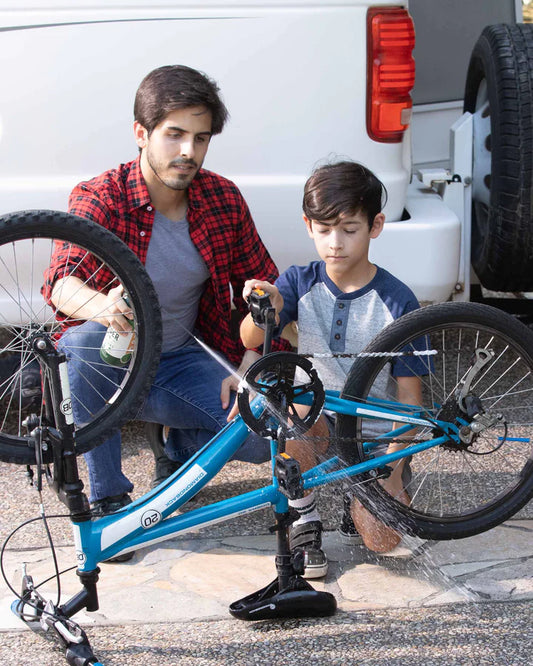 father and son using a safe environmentally friendly spray lubricant on a bike chain