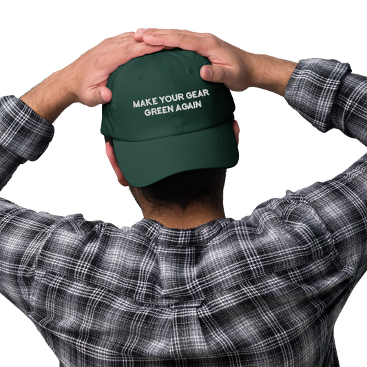 A man wearing a green hat backwards that says, make your gear green again.