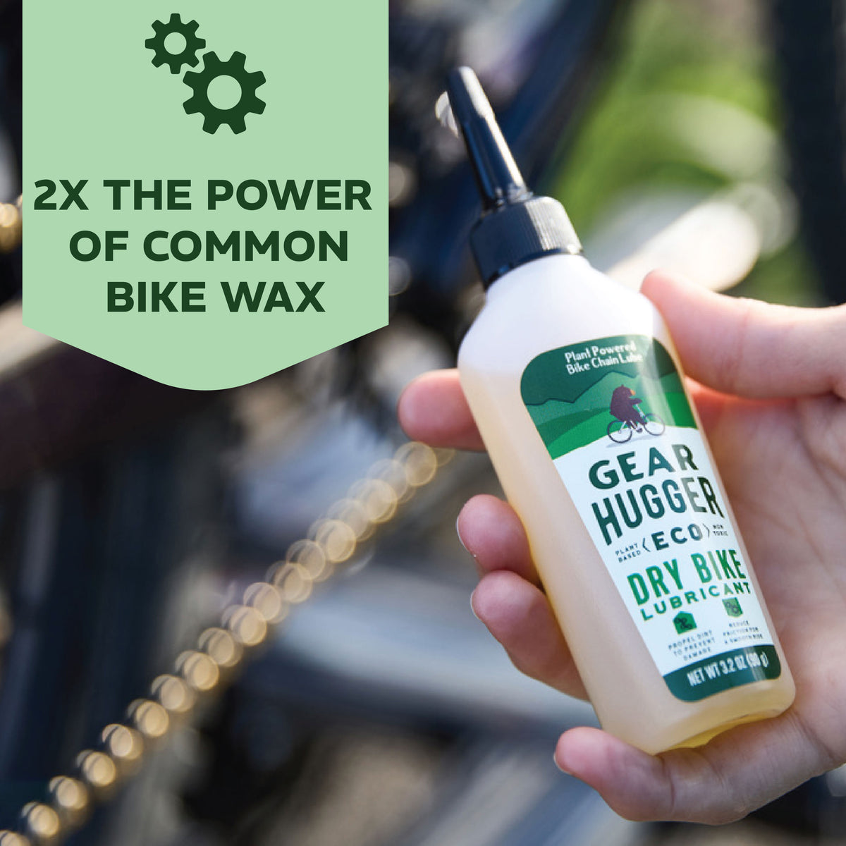 Eco dry bike lubricant held near bike chain - 2x the power of common bike wax, plant-based formula