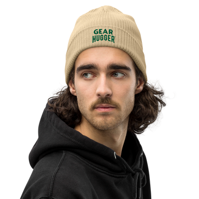 Organic looking beige beanie with the text gear hugger on it.