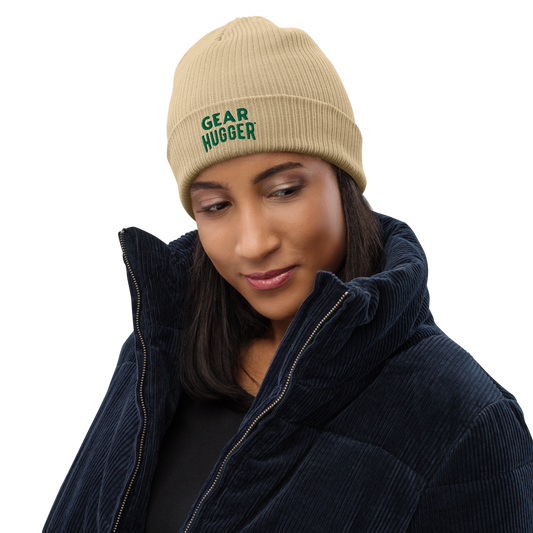 Woman posing with a beige coloured beanie on it that says, gear hugger.