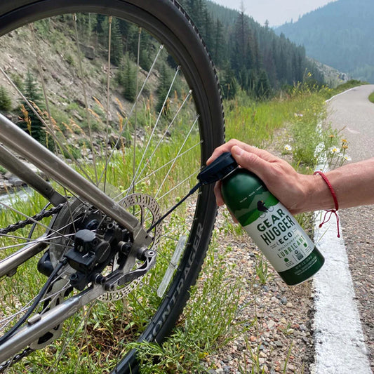 spraying lubricant on a bicycle wheel and chain to stop squeak and rust